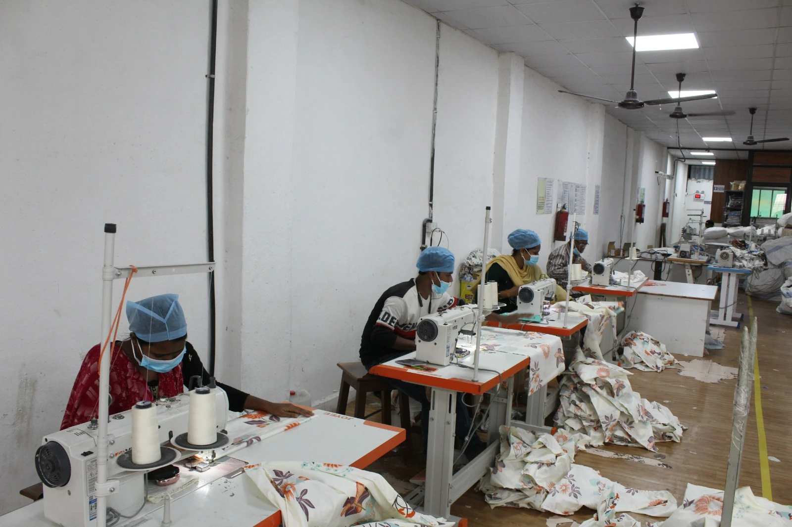 Textile workers stitching fabric in a bright workshop